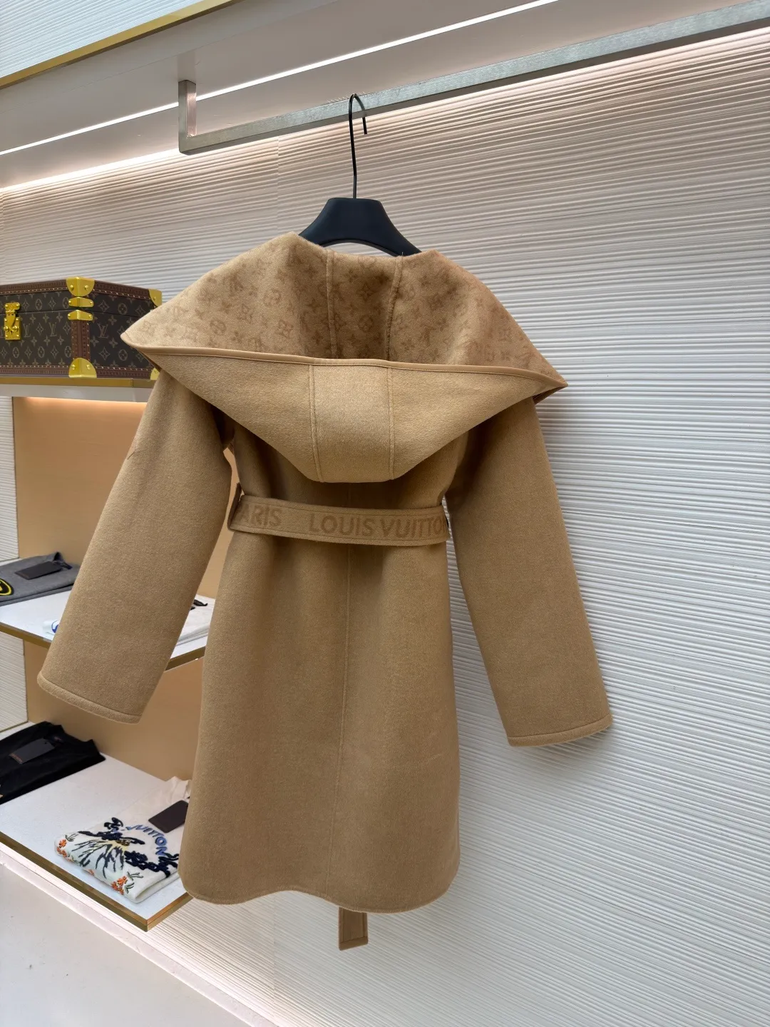 LOUIS VUITTON Wool lace-up wrap hooded coat (mid-length) ●Item number: 1682299-J025 ●Fabric: wool fabric ●Technology: jacquard production ●Color: khaki ●Version: loose fit ●Weight: about 1725 grams ●Size: 34-36-38-40 ●Description: This presbyopic wool coat is made of double-sided blended wool fabric imported from Italy. The main part is made of high-density matte black wool, which has been pre-shrunk and steam-set to ensure that the fabric is stiff and not easily deformed. The large lapel and belt areas use jacquard weaving technology to present the classic presbyopic pattern as a three-dimensional texture. The pattern is digitally positioned and plated to ensure that the texture is symmetrical and clear. The body of the garment is unlined and double-sided sewn to reduce the weight of the garment while improving skin-friendliness. The cuffs and hem are hand-stitched to reveal exquisite details. The waist is customized with a wide belt of the same fabric, with an adjustable buckle design with invisible stitching, allowing the silhouette to be freely adjusted; the neckline adopts a double-layer composite structure, combined with the fixation process of hand-made arch stitches, to make the large lapels more three-dimensional. Every splicing follows the precision sewing standard of 1cm/8 stitches, perfectly integrating craftsmanship and design aesthetics. The overall wiring is straight and delicate, the fabric is comfortable and soft, and the color is consistent without color difference. It can be matched with the same style to create a fashionable look and control various occasions. Customized accessories, complete with three standards, same style for men and women!
